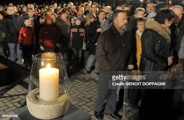 Candle is burning as people gather to commemorate the victims of a knife attack at a Belgian creche last week, in Dendermonde on January 26, 2009. In...