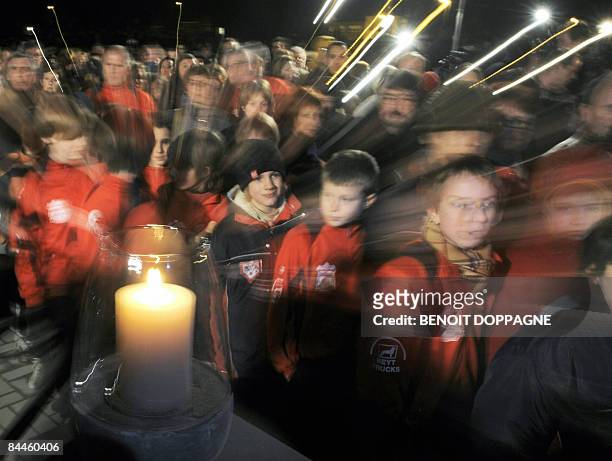Candle is burning as people gather to commemorate the victims of a knife attack at a Belgian creche last week, in Dendermonde on January 26, 2009. In...