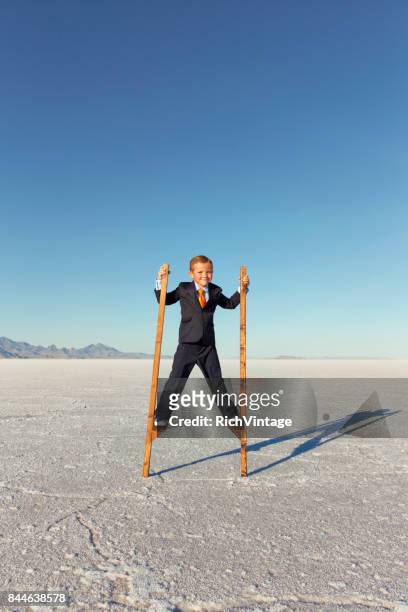 young business boy walking on stilts - stilt stock pictures, royalty-free photos & images