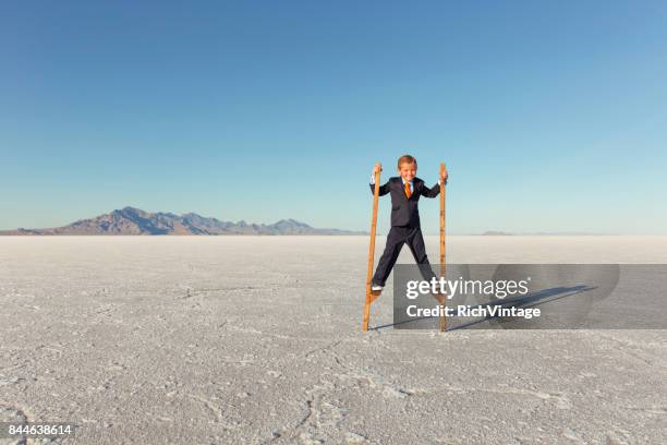 young business boy walking on stilts - stilt stock pictures, royalty-free photos & images