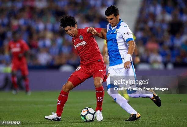 Gaku Shibasaki of Getafe competes for the ball with Ezequiel Munoz of Leganes during the La Liga match between Leganes and Getafe at Estadio...