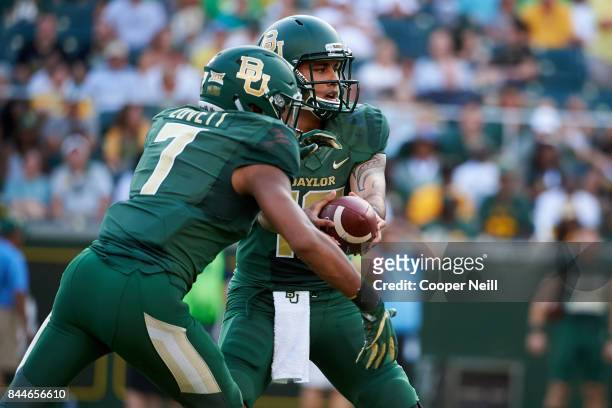 Anu Solomon of the Baylor Bears hands the ball off to John Lovett against the Liberty Flames during a football game at McLane Stadium on September 2,...