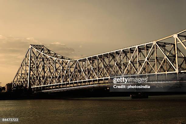 bridge across a river, howrah bridge, hooghly river, calcutta, west bengal, india - howrah bridge stock pictures, royalty-free photos & images