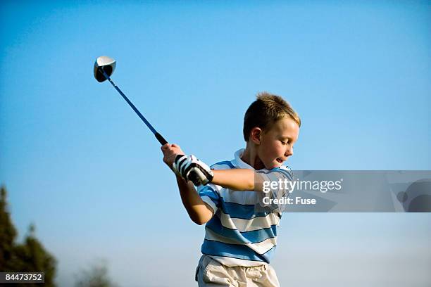 boy taking a swing - young golfer stock pictures, royalty-free photos & images