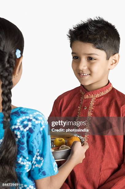 brother and his sister celebrating raksha bhandan - raksha bandhan stock-fotos und bilder