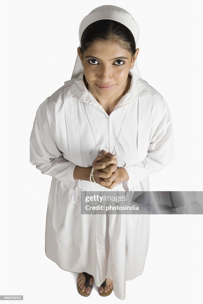 Portrait of a nun standing in a prayer position