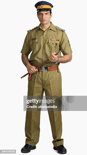 portrait of a policeman holding a nightstick - indian police officer image with uniform stock-fotos und bilder