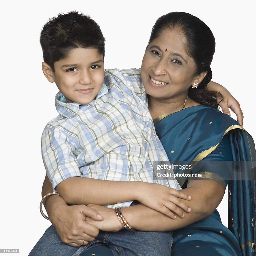 Boy sitting on the lap of her grandmother and smiling