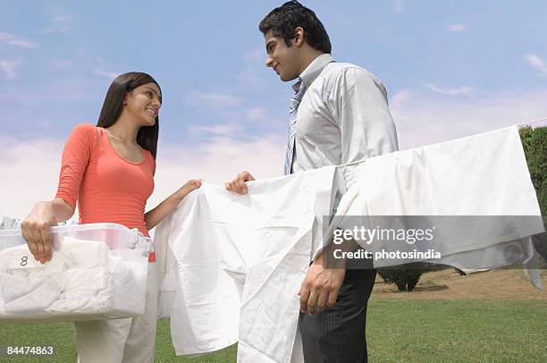 couple looking at each other and smiling - hanging in garden photos et images de collection