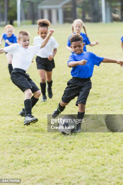 children playing soccer, boy kicking the ball - stage seven stock pictures, royalty-free photos & images