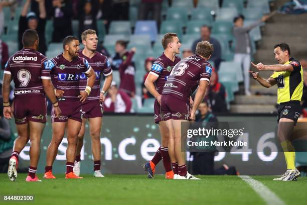 Dylan Walker watches on as Jake Trbojevic and Daly Cherry-Evans of the Sea Eagles argue with referee Gerard Sutton after the try to Tyrone Peachey of...