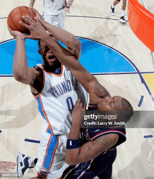 Stromile Swift of the New Jersey Nets tries to block a shot against Russell Westbrook of the Oklahoma City Thunder at the Ford Center on January 26,...