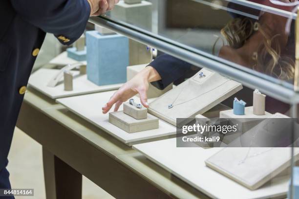 verkoopster helpen mens winkel voor sieraden - vitrinekast stockfoto's en -beelden