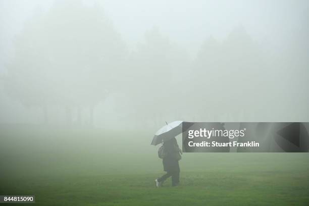 Fans walk around the course sheltering from the rain during Day Three of the 2017 Omega Masters at Crans-sur-Sierre Golf Club on September 9, 2017 in...