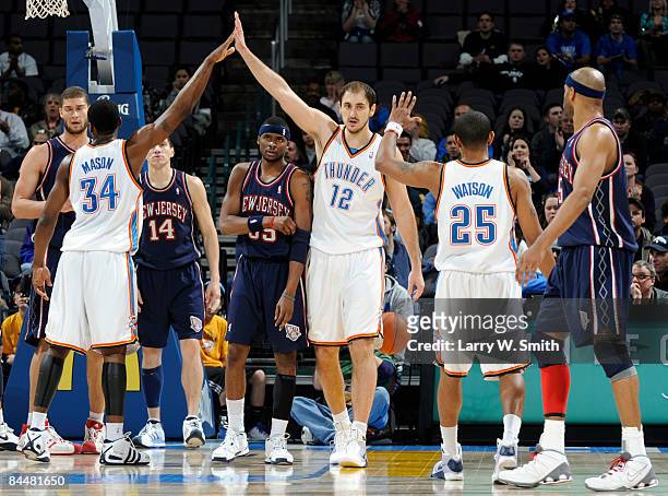 Nenad Krstic of the Oklahoma City Thunder celebrates with teammates Desmond Mason and Earl Watson against the New Jersey Nets at the Ford Center on...