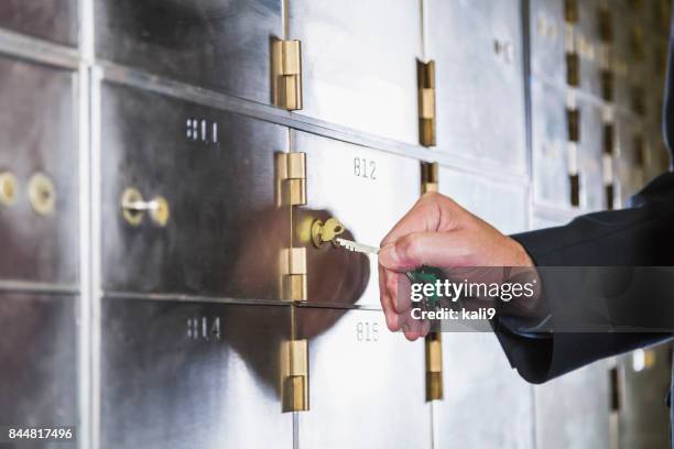 man unlocking a safety deposit box - vaulted door stock pictures, royalty-free photos & images