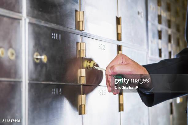 man unlocking a safety deposit box - cofre imagens e fotografias de stock