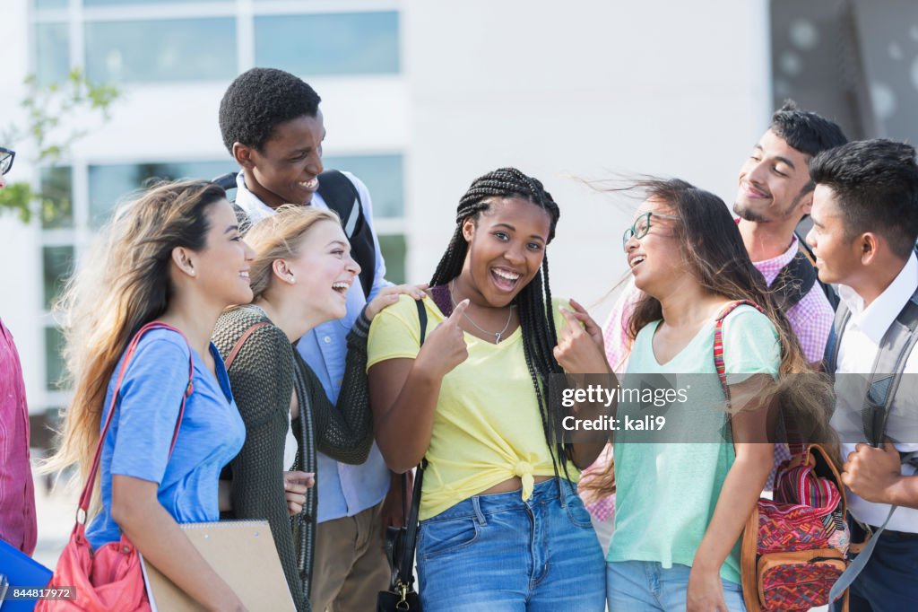 Teenage girl with multi-ethnic friends outside school