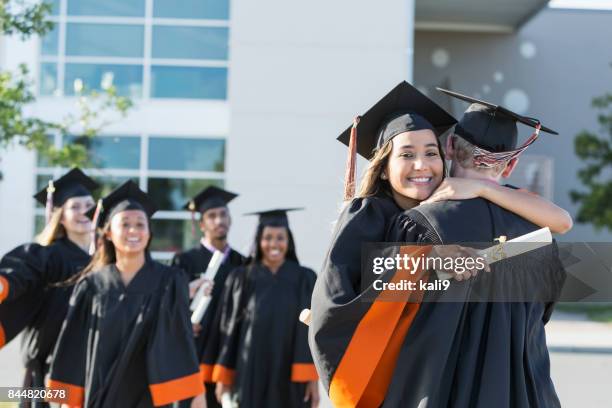 hispanic female graduate hugging friend - secondary school certificate stock pictures, royalty-free photos & images