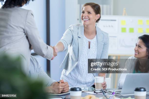 female executive greets colleague - president and vice president stock pictures, royalty-free photos & images