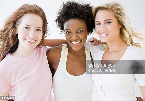 three women with their arms around each other - three people white background stock pictures, royalty-free photos & images