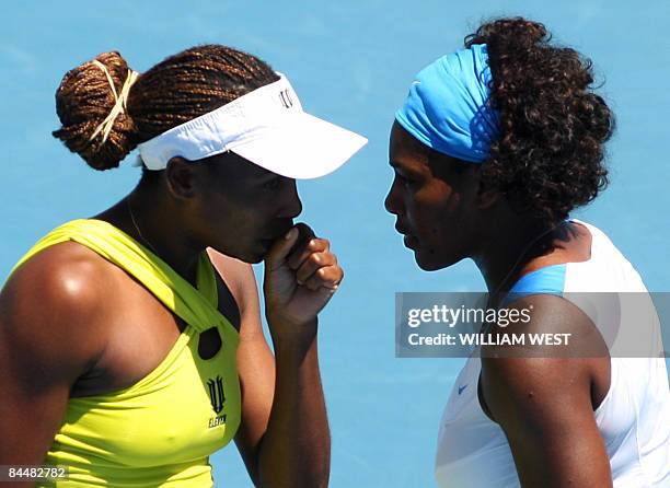 Venus and Serena Williams of the US discuss their game plan against Peng Shuai of China and partner Hsieh Su-Wei of Taiwan during their women's...