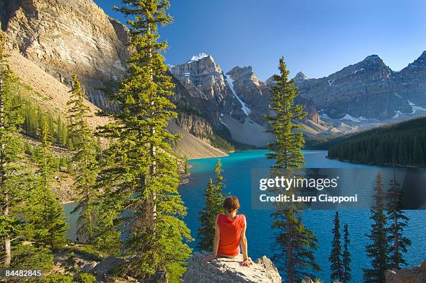 woman sitting on rock at lake moraine - viewpoint stock pictures, royalty-free photos & images