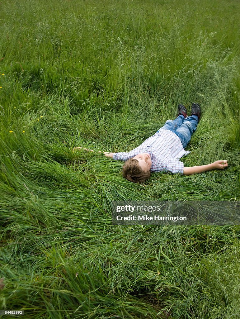 Boy laying in green grass