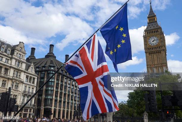 An EU and a Union Flag are seen in front of Elizabeth Tower during a pro-EU rally at the People's March for Europe against Brexit in Parliament...