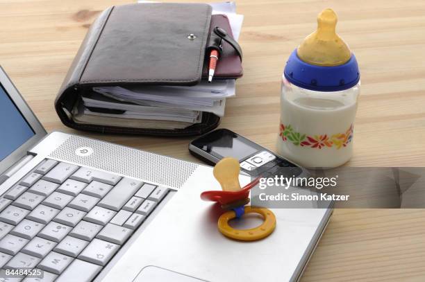 detail of an office desk with baby utensils - schnuller stock-fotos und bilder