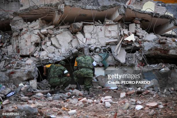 Soldiers with specially trained dogs search for survivors amid the ruins of buildings knocked down Thursday night by a 8.1-magnitude quake, in...