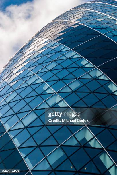 looking up at the famous gherkin building in london's financial district against a cloudy blue sky - sir norman foster building fotografías e imágenes de stock