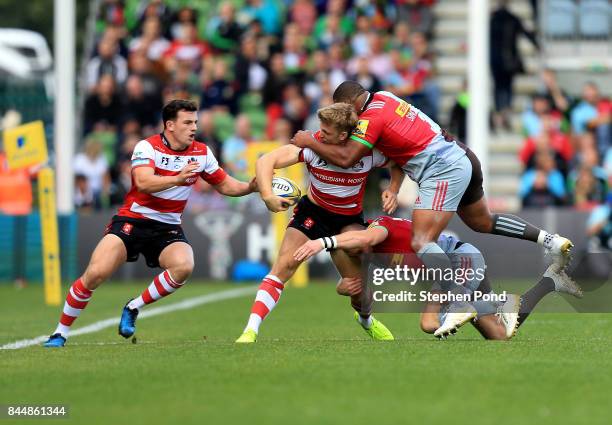 Ollie Thorley of Gloucester Rugby is tackled by Mike Brown and Kyle Sinckler of Harlequins during the Aviva Premiership match between Harlequins and...