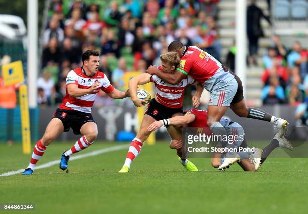 Ollie Thorley of Gloucester Rugby is tackled by Mike Brown and Kyle Sinckler of Harlequins during the Aviva Premiership match between Harlequins and...