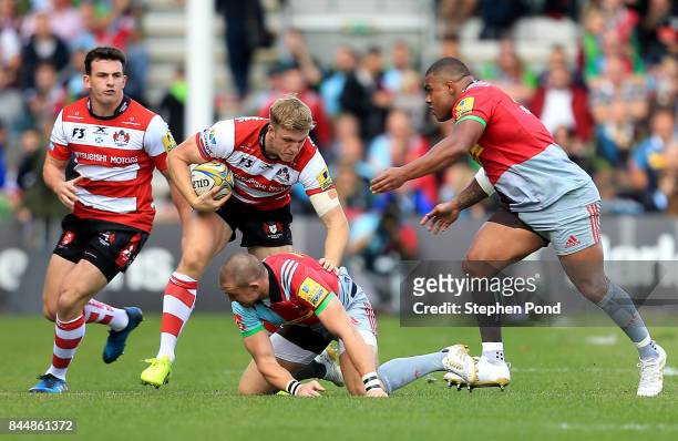 Ollie Thorley of Gloucester Rugby is tackled by Mike Brown and Kyle Sinckler of Harlequins during the Aviva Premiership match between Harlequins and...