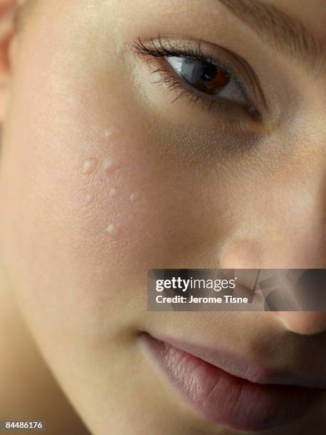 close-up of water droplets on young woman's cheek - belle peau photos et images de collection