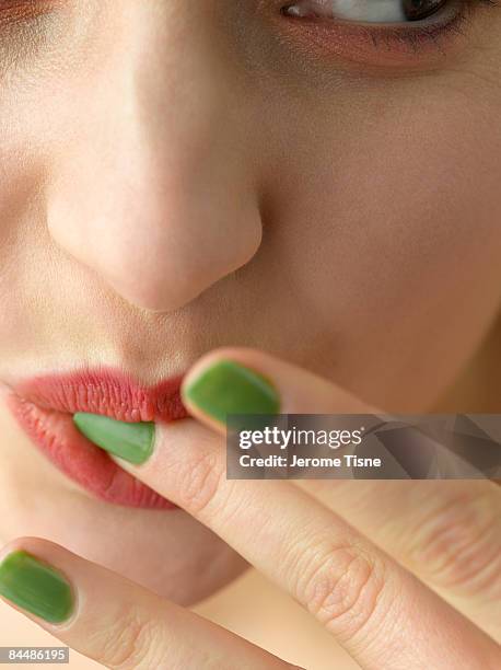 close up of a young woman licking finger - finger in mouth stockfoto's en -beelden