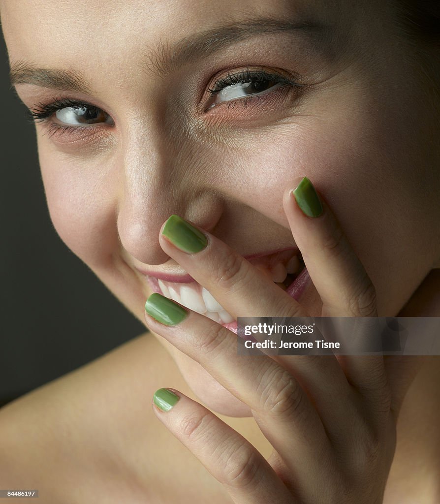 Young woman smiling behind her hand