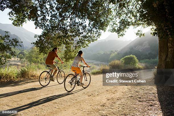 aktive paar radfahren auf scenic road ab. - fahrrad natur stock-fotos und bilder