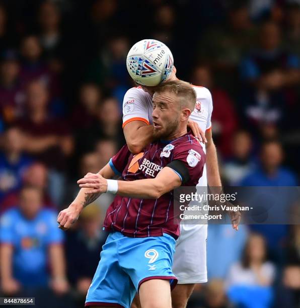 Scunthorpe United's Paddy Madden vies for possession with Blackpool's Clark Robertson during the Sky Bet League One match between Scunthorpe United...