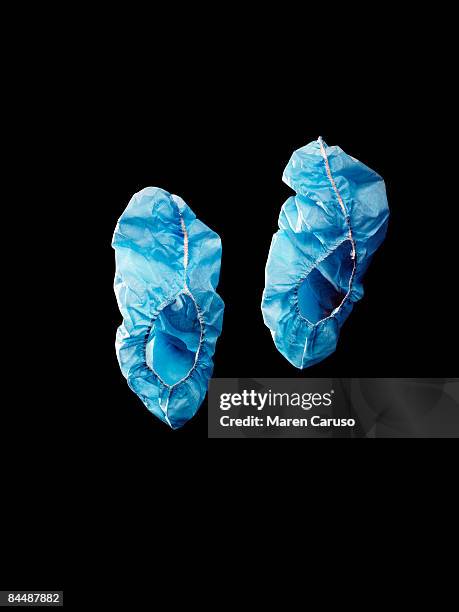 blue surgical booties shot on black. - blue shoe covers stock pictures, royalty-free photos & images