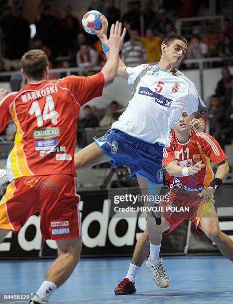 Macedonia's Stojanche Stoilov tries to score in front of Serbia's Mladen Bojinovic and Alem Toskic during their World Handball Championship match in...
