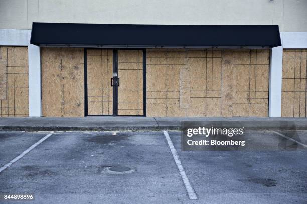 Boards cover the windows and doors of a Men's Wearhouse Inc. Location ahead of Hurricane Irma in Tampa, Florida, U.S., on Saturday, Sept. 9, 2017....