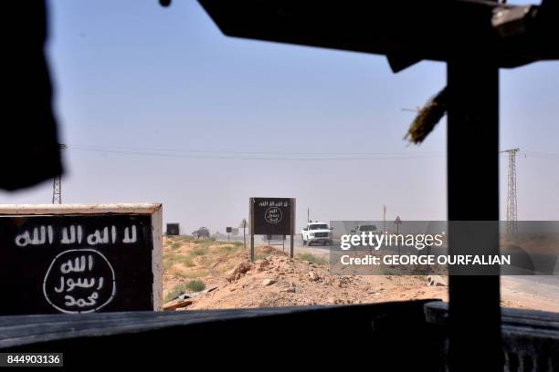 Billboards show the logo of the Islamic State group near the village of al-Maleha, in the northern countryside of Deir Ezzor, where Syrian...