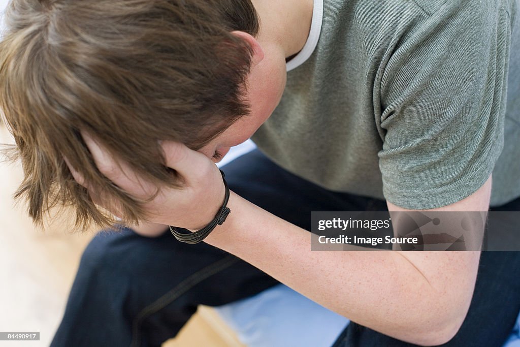 A teenage boy crying