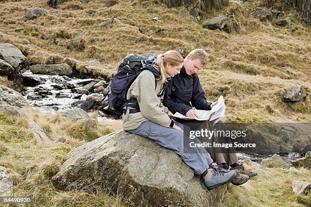 a couple looking at a map  - north wales map stock pictures, royalty-free photos & images
