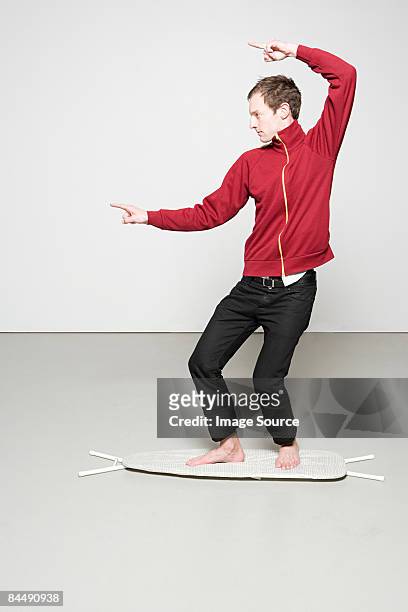 man surfing on an ironing board - house husband stock pictures, royalty-free photos & images