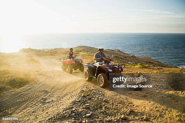 people riding all terrain vehicles - quad foto e immagini stock