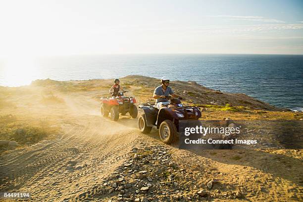 people riding all terrain vehicles - atv riding beach stock pictures, royalty-free photos & images