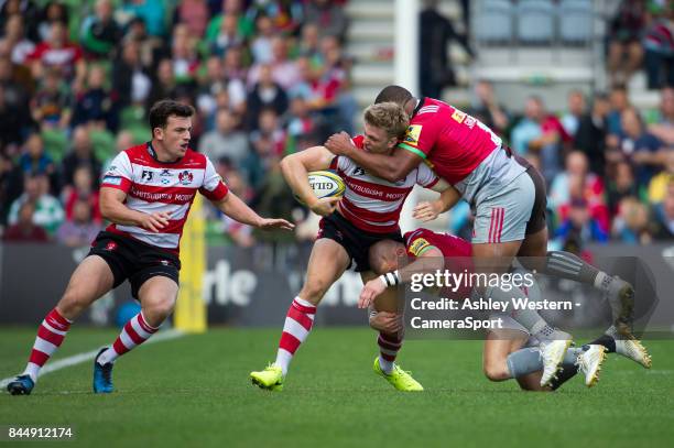 Gloucester Rugby's Ollie Thorley offloads to Matt Scott as he is tackled by Harlequins' Kyle Sinckler and Mike Brown during the Aviva Premiership...
